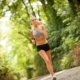 woman jogging down dirt path in forrest